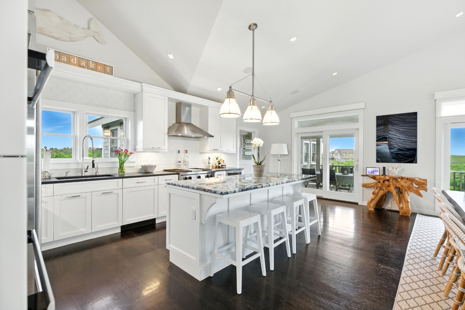 45 Starbuck Road Nantucket, MA 02554 - Photo 9 of 42 a large kitchen with kitchen island a dining table chairs and a wooden floor