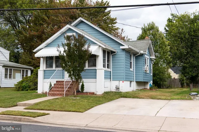 a view of house with a yard and potted plants