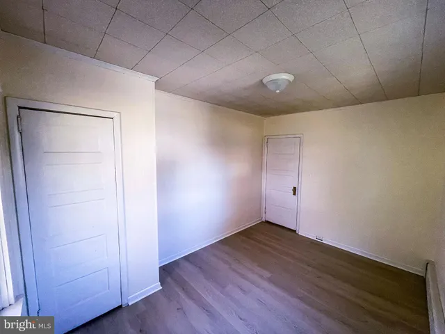 an empty room with wooden floor and closet