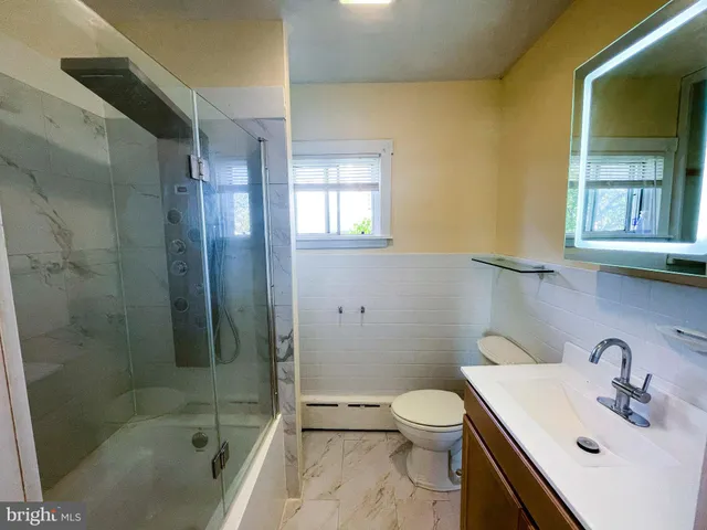 a bathroom with a sink a toilet and shower