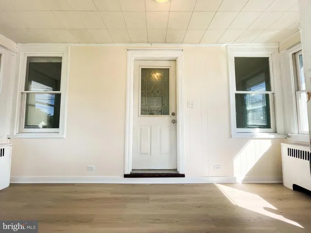 a view of a hallway with a window and wooden floor