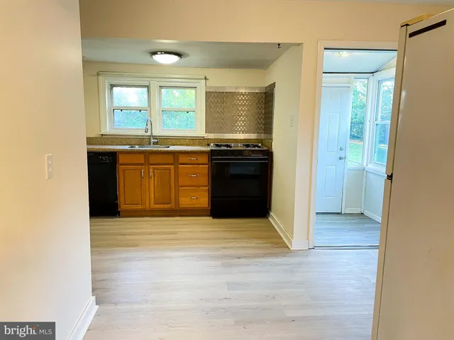 a view of a kitchen with granite countertop a refrigerator and a sink