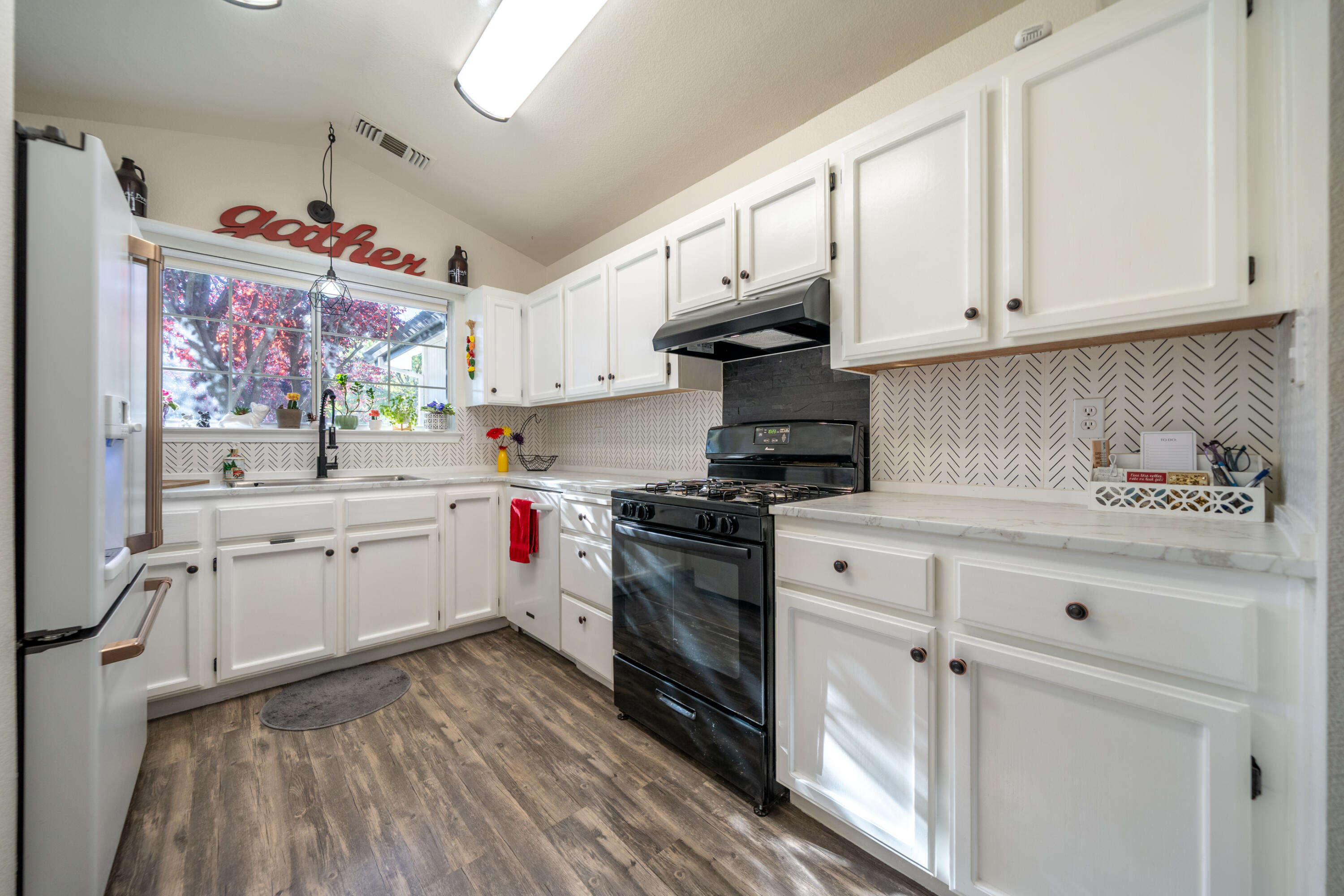 874 Spaniel Drive Redding, CA 96003 - Photo 13 of 41 a kitchen with granite countertop white cabinets and white appliances