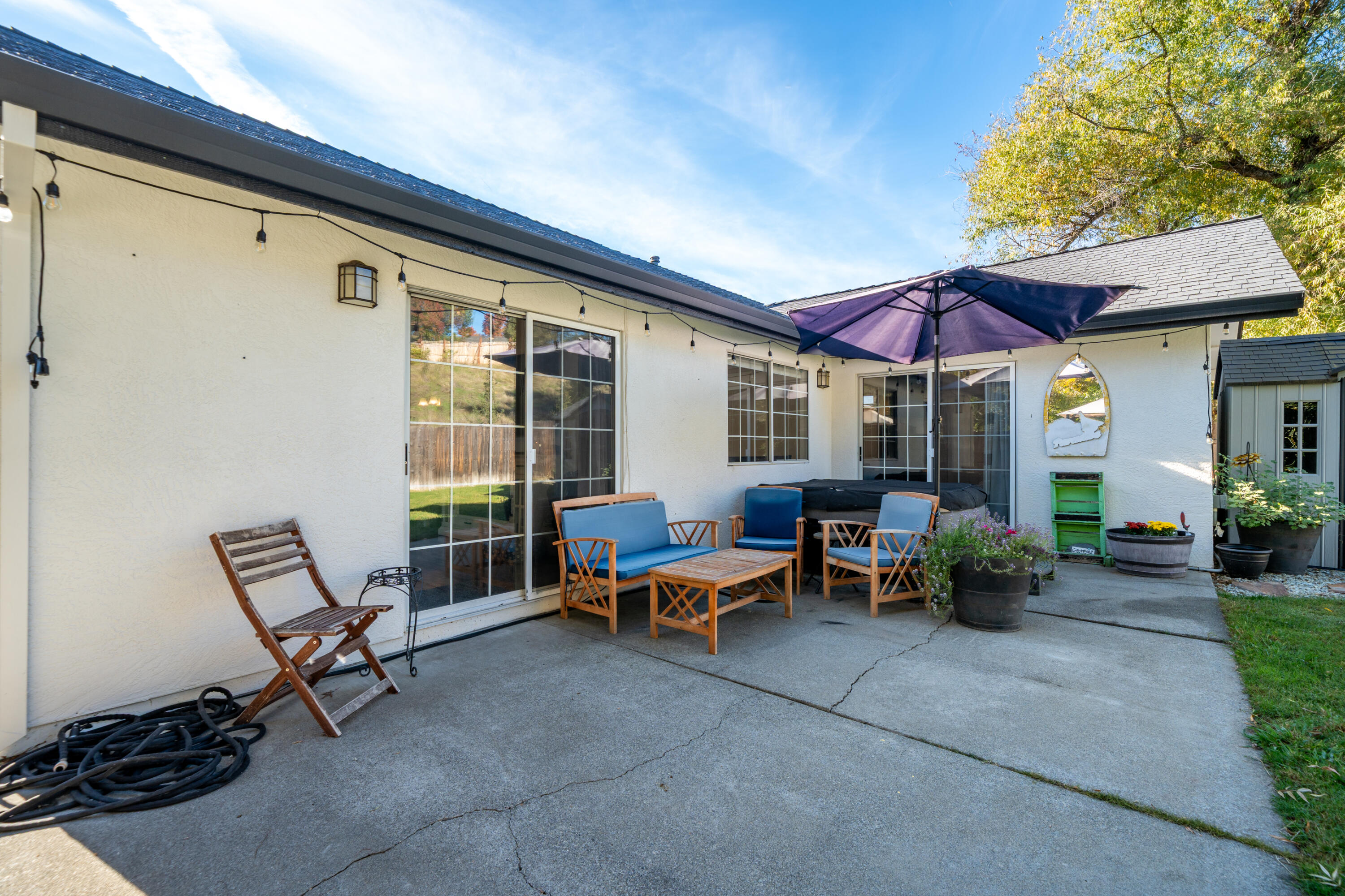 874 Spaniel Drive Redding, CA 96003 - Photo 30 of 41 a view of a patio with a table and chairs under an umbrella