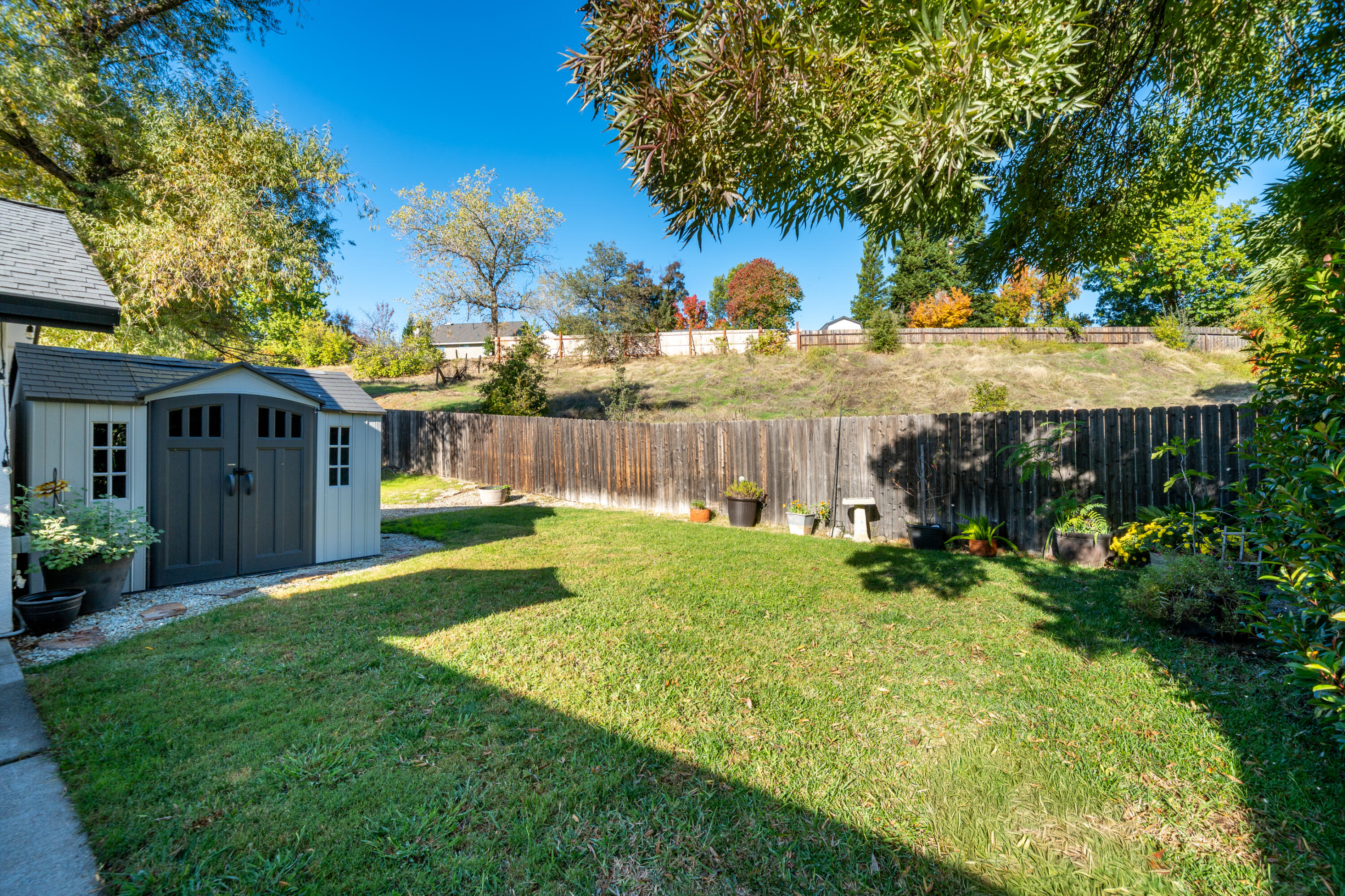 874 Spaniel Drive Redding, CA 96003 - Photo 33 of 41 a view of backyard with table and chairs and wooden fence