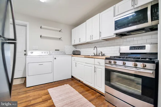 a kitchen with white cabinets stainless steel appliances and sink