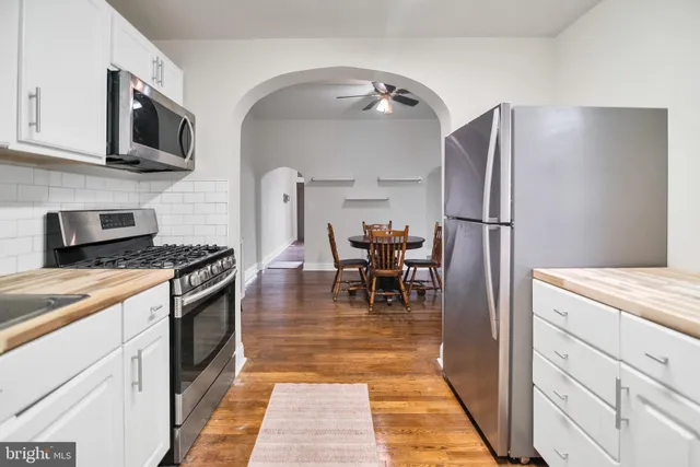 a kitchen with stainless steel appliances granite countertop a refrigerator stove microwave and cabinets