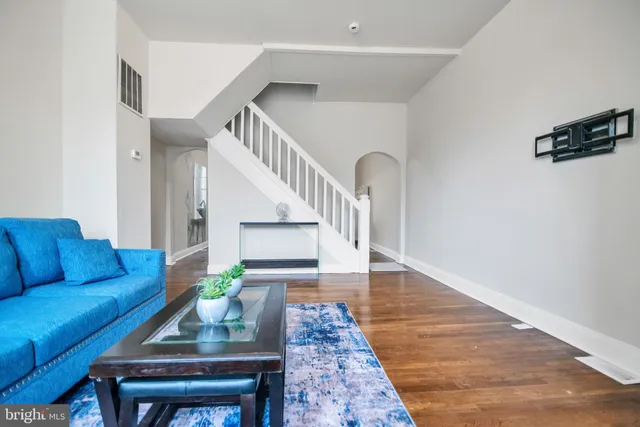 a living room with furniture and a wooden floor