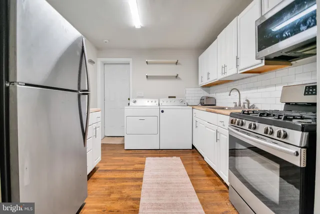 a white kitchen with a sink a stove and refrigerator