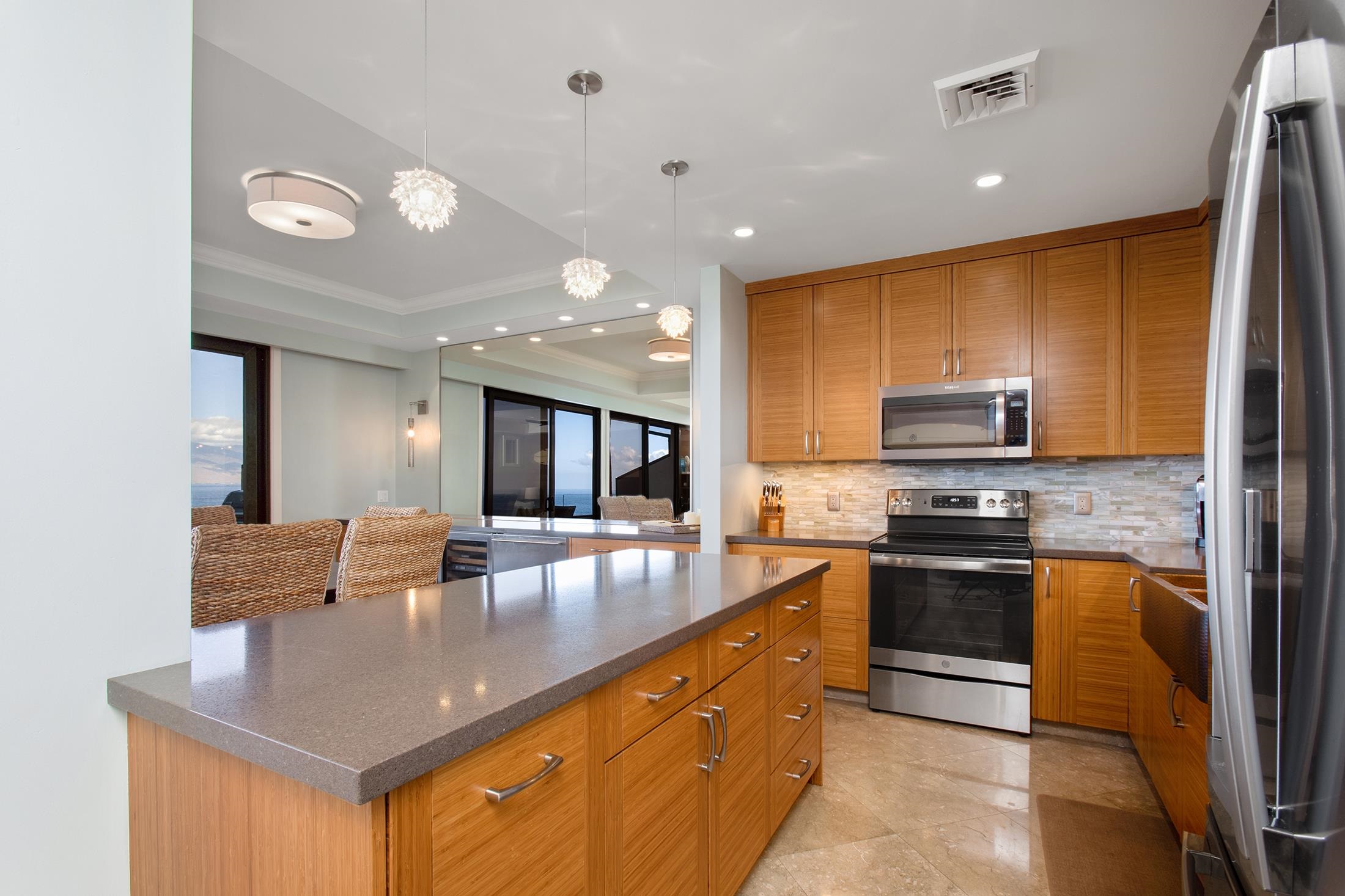 4850 Makena Alanui Road, Unit F207 Kihei, HI 96753 - Photo 11 of 34 a kitchen with stainless steel appliances granite countertop a sink refrigerator and cabinets