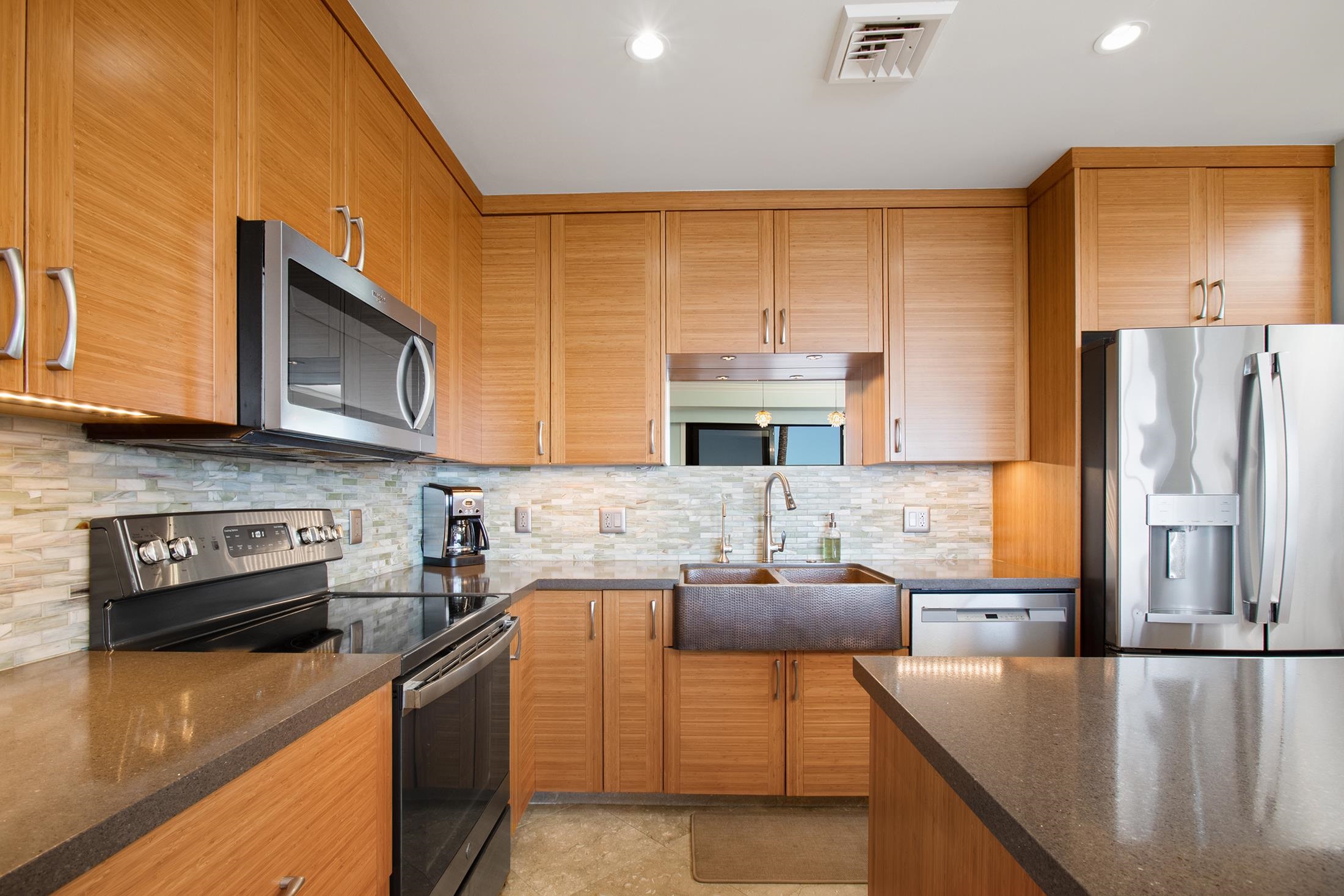 4850 Makena Alanui Road, Unit F207 Kihei, HI 96753 - Photo 12 of 34 a kitchen with stainless steel appliances granite countertop a sink and a refrigerator