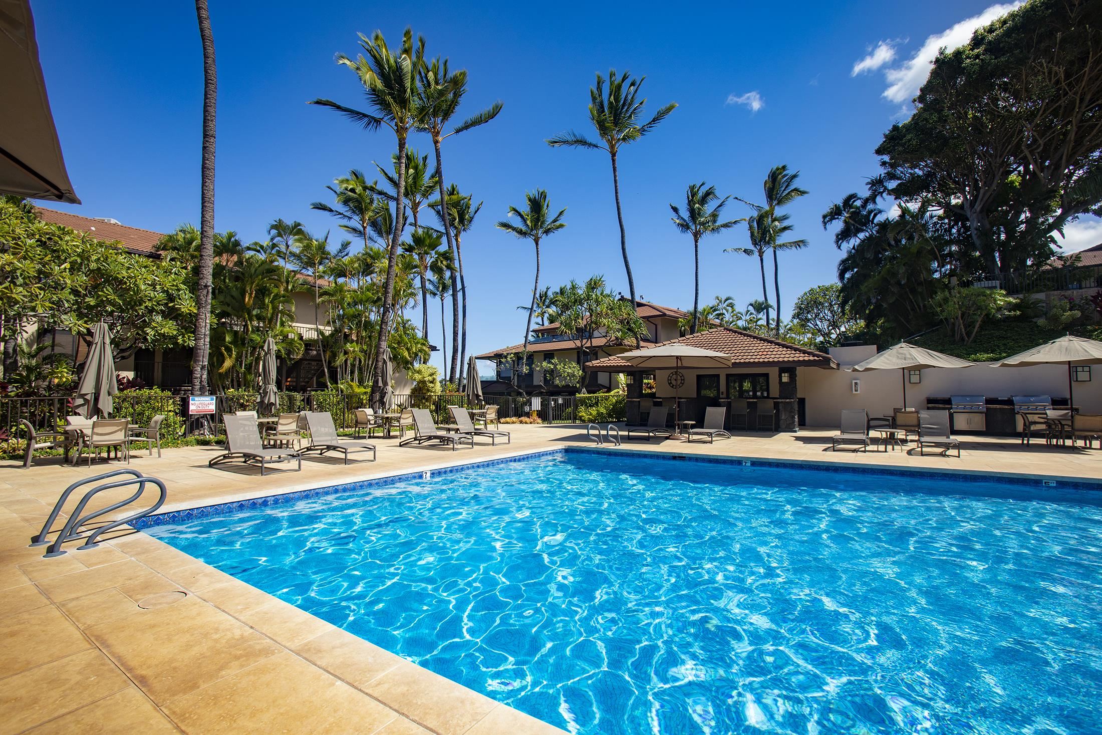 4850 Makena Alanui Road, Unit F207 Kihei, HI 96753 - Photo 33 of 34 a view of a swimming pool with lawn chairs under an umbrella