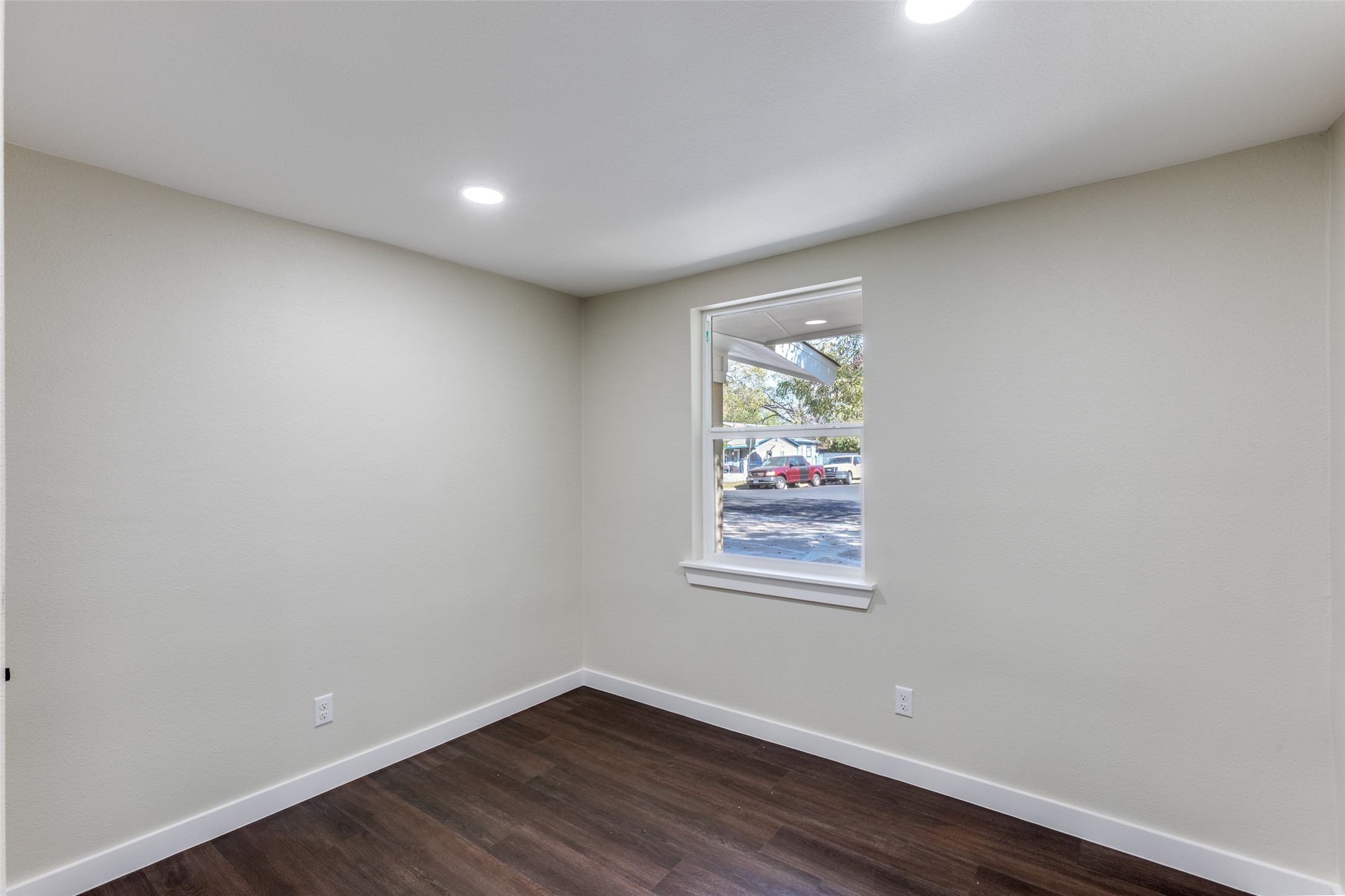1118 Spur Street Austin, TX 78721 - Photo 7 of 21 A well-lit interior space features sleek dark wood flooring and a large window inviting natural light.
