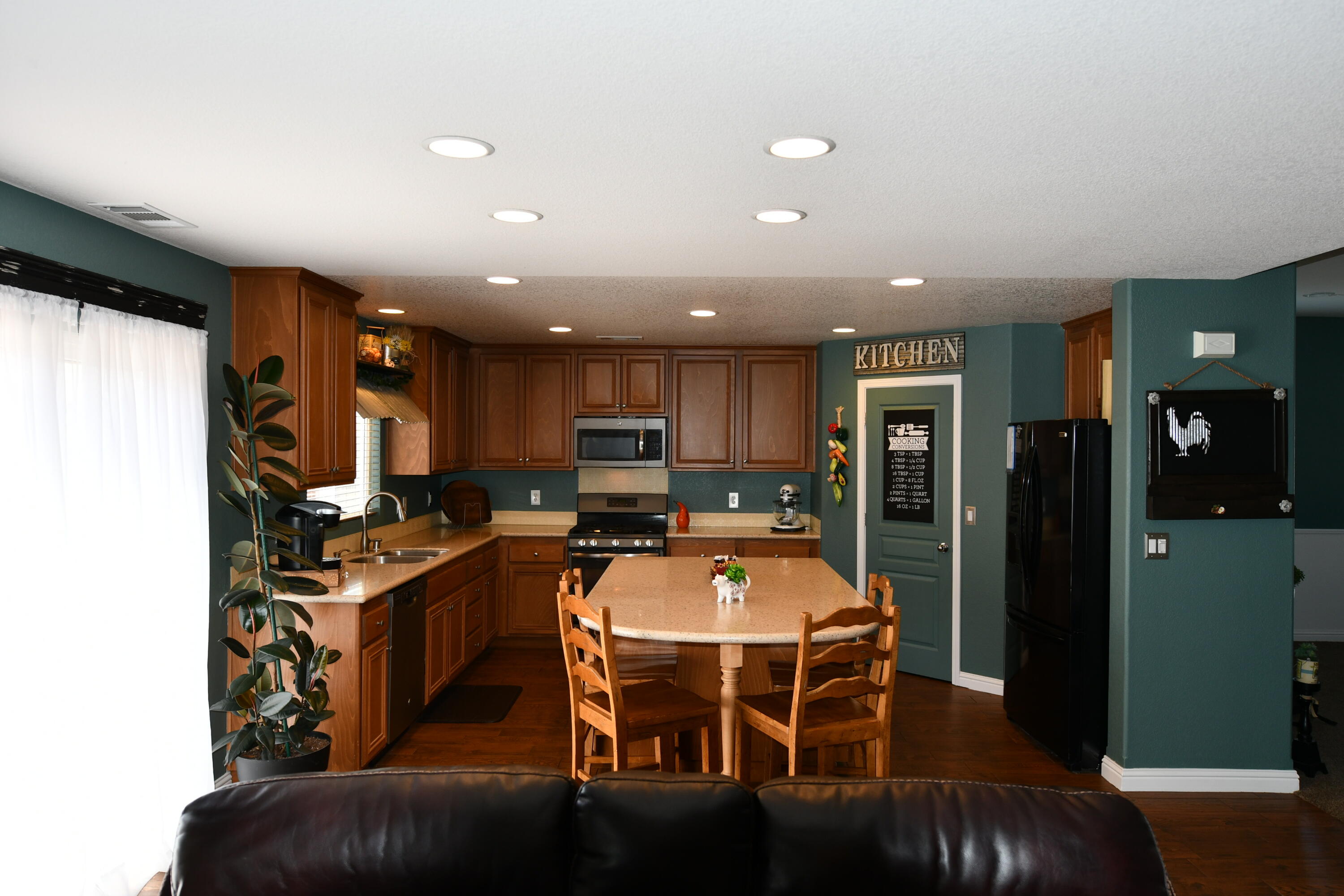 2316 Point Sal Loop Lompoc, CA 93436 - Photo 10 of 36 a kitchen with stainless steel appliances kitchen island granite countertop a refrigerator a stove a sink a dining table and chairs with wooden floor