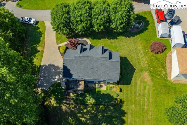 an aerial view of a house with a yard and large trees