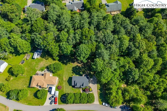 an aerial view of residential house with outdoor space and trees all around