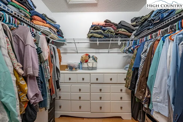 a view of walk in closet with clothes and shoes