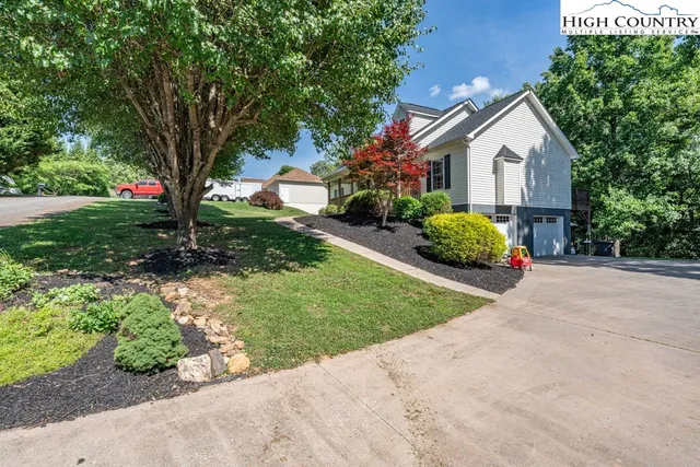 a front view of a house with a yard and a garden