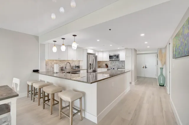 a kitchen with stainless steel appliances granite countertop a refrigerator sink and stove