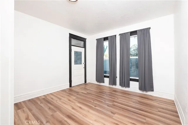 a view of a bedroom with wooden floor and bathroom