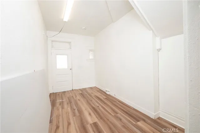a view of a room with wooden floor and white walls