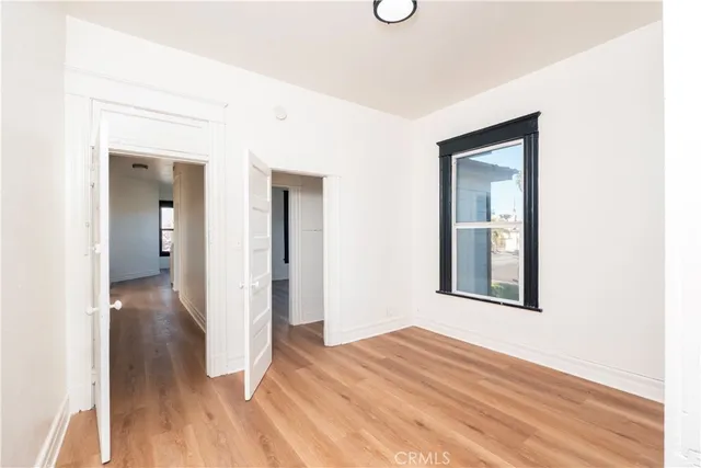 a view of a hallway with wooden floor and closet