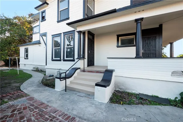 a view of a patio with couches table and chairs with wooden floor and fence