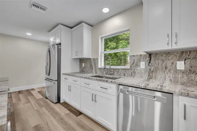 a kitchen with stainless steel appliances granite countertop a sink stove and refrigerator