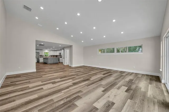 a view of empty room with wooden floor and windows