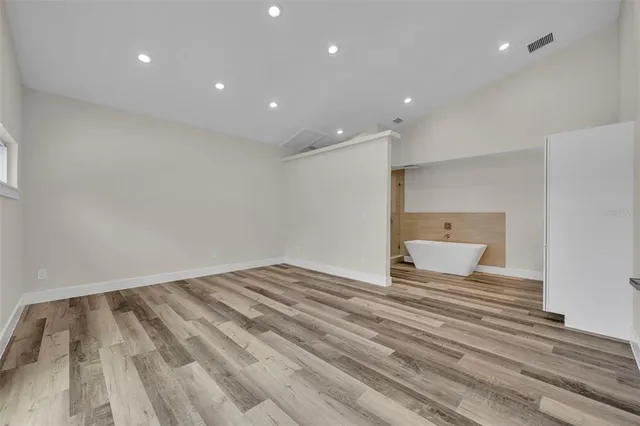 a view of empty room with wooden floor