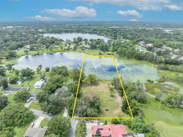 an aerial view of residential houses with outdoor space and lake view