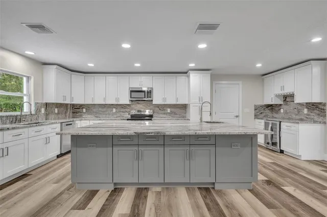 a kitchen with stainless steel appliances granite countertop a stove a sink and a refrigerator
