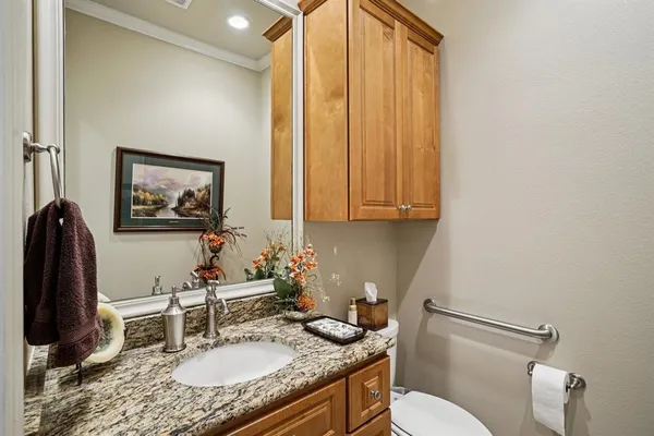 a bathroom with a granite countertop sink a mirror and a toilet