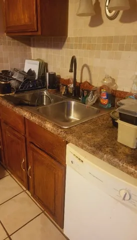 a kitchen with granite countertop a sink and a stove top oven