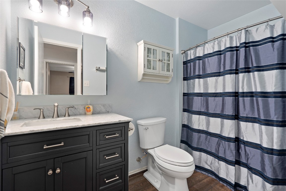 8609 Claude Court Austin, TX 78747 - Photo 13 of 30 a bathroom with a toilet sink and a mirror