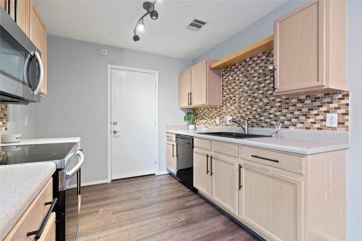 8609 Claude Court Austin, TX 78747 - Photo 4 of 30 a kitchen with a sink stove and cabinets