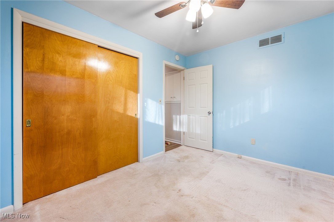 844 Roseland Road Alliance, OH 44601 - Photo 33 of 40 Unfurnished bedroom with light colored carpet, a closet, and ceiling fan