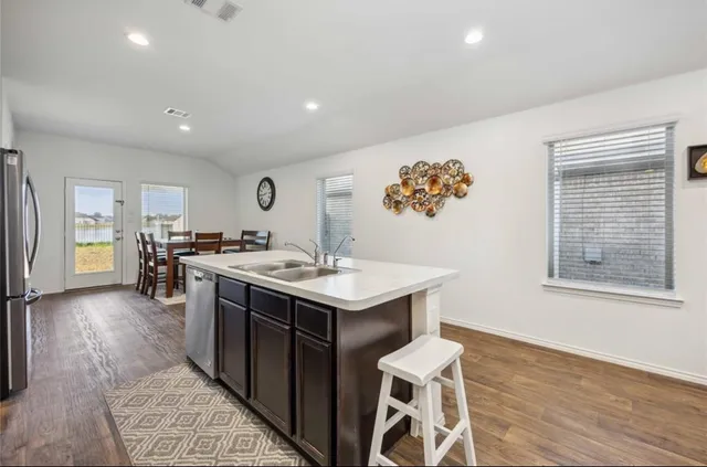 a kitchen with a sink and chairs