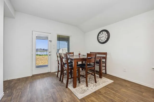 a view of a dining room and livingroom with furniture wooden floor and a rug