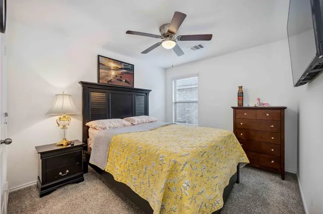 a bedroom with a bed and a tv on the dresser