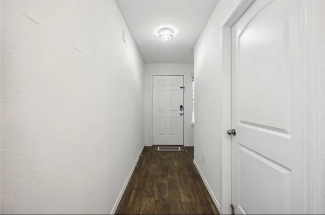 a view of a hallway with wooden floor