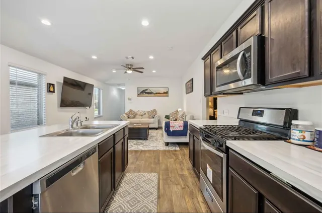 a kitchen with stainless steel appliances granite countertop a sink stove and cabinets