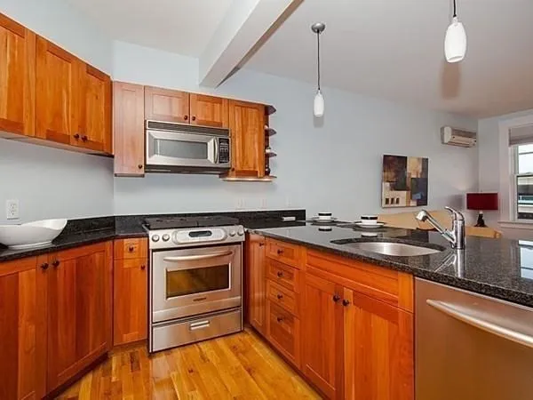a kitchen with stainless steel appliances a stove sink microwave and cabinets