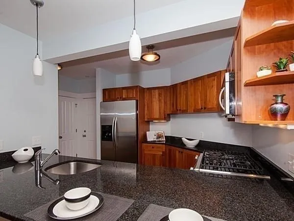 a kitchen with stainless steel appliances granite countertop a sink stove and refrigerator