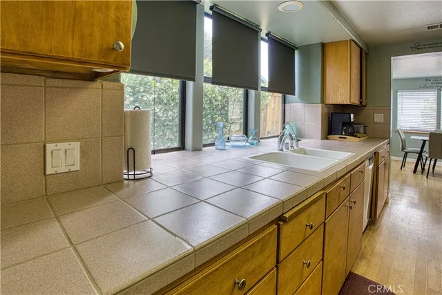 a kitchen with a stove a sink and wooden floor