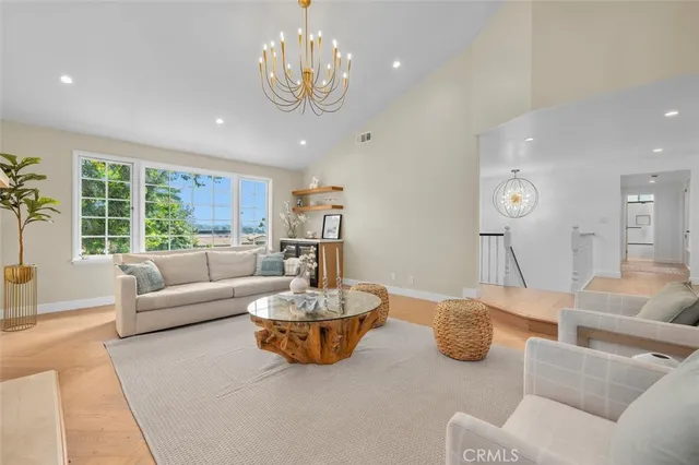 a living room with furniture kitchen and a large window
