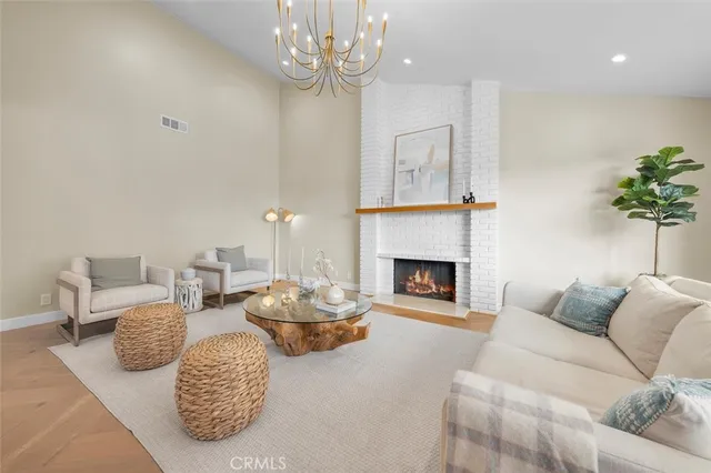 a living room with furniture a fireplace and a chandelier