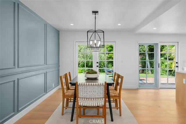 a dining room with furniture a chandelier and wooden floor