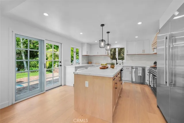 a kitchen with stainless steel appliances granite countertop sink stove and refrigerator