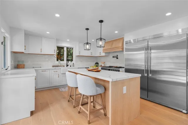 a kitchen with a refrigerator a sink and a stove top oven